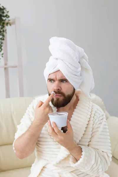 Vicces ember, aki hatásos krémet használ az arcbőrén. Spa otthon, test és bőr gondozás a férfi koncepció. — Stock Fotó