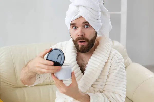 Retrato de homem aplicando creme eficaz em sua pele facial. Spa em casa, corpo e cuidados com a pele para o conceito masculino. — Fotografia de Stock