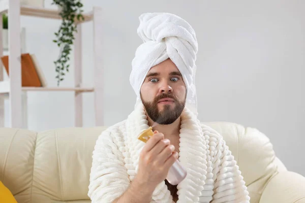 Homem barbudo com toalha de banho na cabeça aplicando tratamento de água spray no rosto. Spa, corpo e cuidados com a pele para o conceito de homem. — Fotografia de Stock