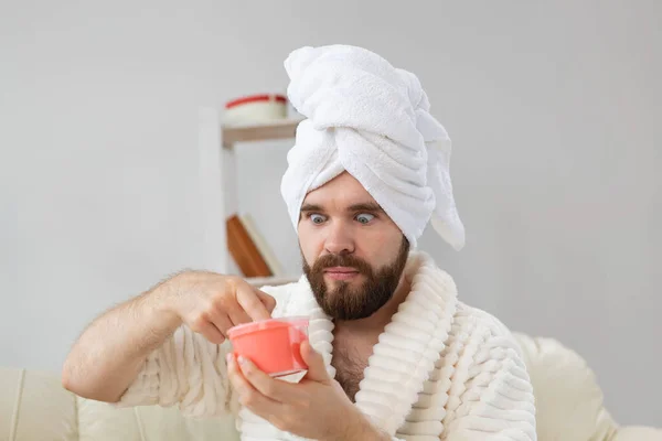 Bonito homem segurando esfoliação rosa cosmética para a pele. Spa, corpo e cuidados com a pele para o conceito de homem. — Fotografia de Stock