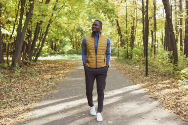 Sonbahar parkında yürüyen Afrikalı Amerikalı hippi.