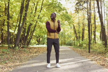 Sonbahar parkında yürüyen Afrikalı Amerikalı hippi.