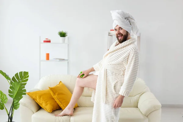 Grappige man met baard draagt tulband handdoek maakt zich een massage met massageborstel. Mannelijke huidverzorging en spa concept. — Stockfoto