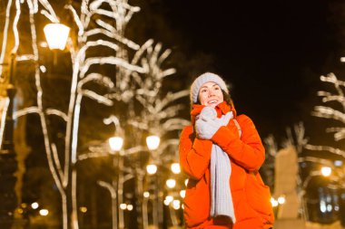 Genç, güzel, komik kız kışın dışarıda eğleniyor. Noel, şehir ve kış tatili konsepti.