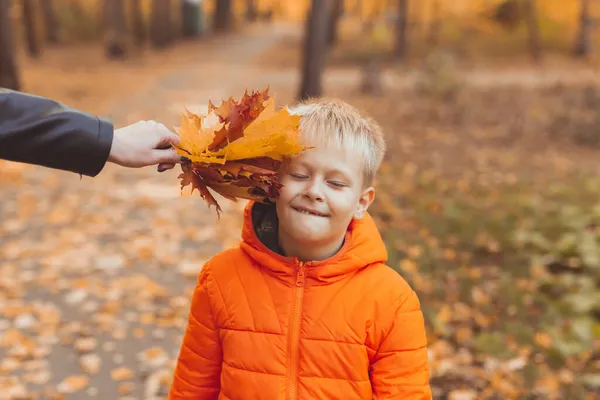 Retrato de menino feliz na jaqueta laranja no parque de outono. Temporada de outono e conceito de crianças — Fotografia de Stock