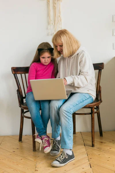 Dziecko i babcia korzystające z laptopa w kuchni. Pokolenie i koncepcja rodziny — Zdjęcie stockowe