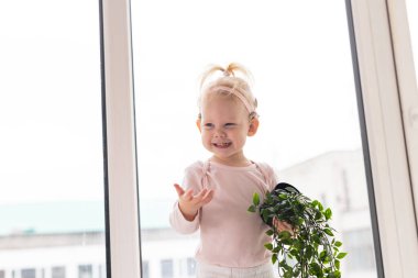 Koklear implantı olan bebek evde eğleniyor. Sağırlık ve tıbbi teknoloji kavramı.