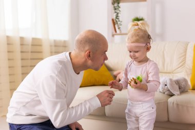 Koklear implantı olan çocuk evde babasıyla eğleniyor. Sağırlık ve tıbbi teknoloji kavramı.