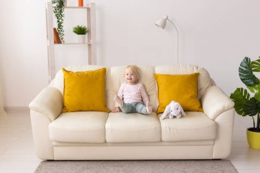 Koklear implantı olan çocuk evde oyuncaklarla oynuyor. Sağırlık ve tıbbi teknoloji kavramı.