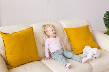 Koklear implantı olan çocuk evde oyuncaklarla oynuyor. Sağırlık ve tıbbi teknoloji kavramı.