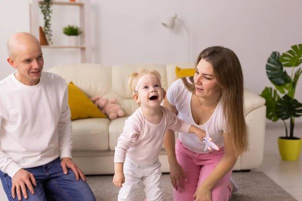 Kind mit Cochlea-Implantaten hat Spaß mit Mutter und Vater zu Hause. Gehörlosigkeit und medizintechnisches Konzept. — Stockfoto
