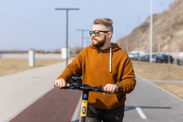 Nowoczesny facet jadący skuterem elektrycznym w mieście. Innowacyjna koncepcja transportu i stylu życia. — Zdjęcie stockowe