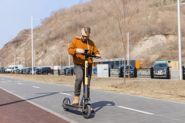 Man betalen voor elektrische scooter via web betaling met behulp van zijn mobiele telefoon. Modern stedelijk vervoersconcept — Stockfoto