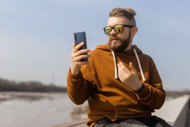 Sosyal medya iletişimi. Açık havada cep telefonu kullanan bir adam görüntüsü.