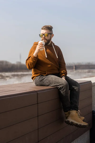 Stijlvolle knappe hipster man met drankjes cocktail, lente tijd — Stockfoto