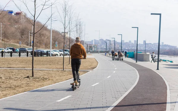 Moderne man rijdt met elektrische scooter in de stad. Innovatief concept voor vervoer en levensstijl. — Stockfoto