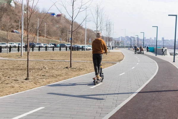 Knappe man die rijdt op elektrische moderne scooter. Ecologisch vervoer, technologisch concept — Stockfoto