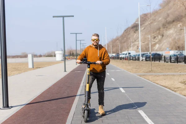 Knappe man die rijdt op elektrische moderne scooter. Ecologisch vervoer, technologisch concept — Stockfoto