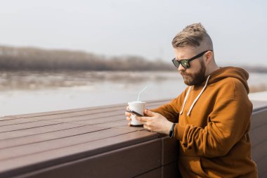 Genç hippi sokakta akıllı telefon kullanıyor. Sosyal medya iletişimi. Metin için boşluk ve yeri kopyala