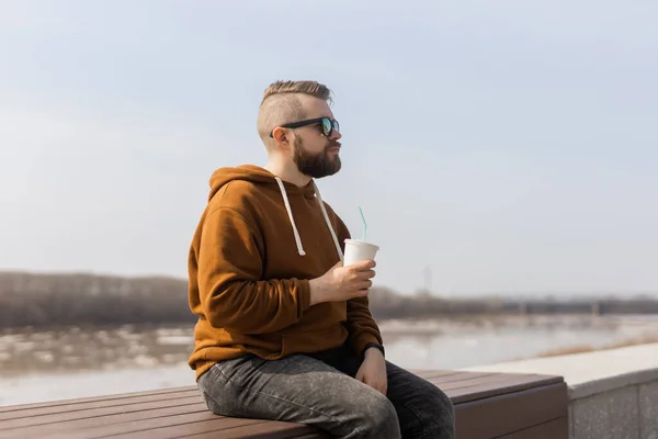 Stijlvolle knappe hipster man met drankjes cocktail, lente tijd. Kopieerruimte — Stockfoto