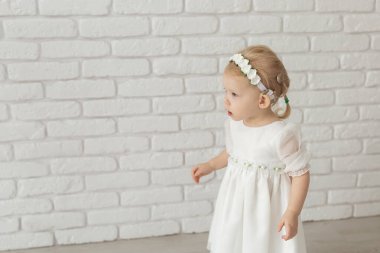 İşitme cihazı ve koklear implantı olan bebek beyaz tuğla duvarda reklam yeri ve fotokopi yeri var. Sağır ve sağlık kavramı