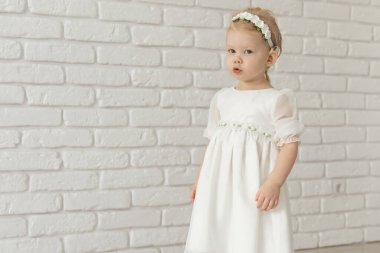 İşitme cihazı ve koklear implantı olan bebek beyaz tuğla duvarda reklam yeri ve fotokopi yeri var. Sağır ve sağlık kavramı