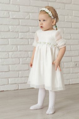 Beyaz tuğla duvarda işitme cihazı ve koklear implantı olan bebek. Sağır ve sağlık kavramı