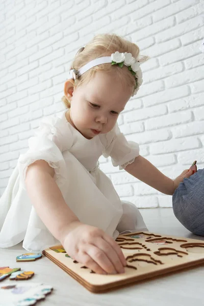 Baby kind met gehoorapparaten en cochleaire implantaten speelt op de vloer. Doof en revalidatieconcept — Stockfoto