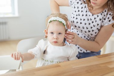 Anne, sağır küçük kızı için koklear implant takmasına yardım ediyor. İşitme cihazı ve sağırlık kavramı