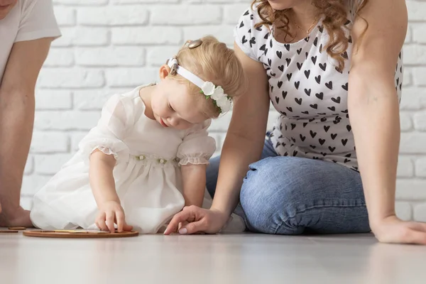 Baby barn med hörapparater och cochleaimplantat leker med föräldrar på golvet. Döv och rehabiliteringskoncept — Stockfoto