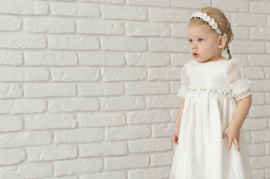 İşitme cihazı ve koklear implantı olan bebek beyaz tuğla duvarda reklam yeri ve fotokopi yeri var. Sağır ve sağlık kavramı