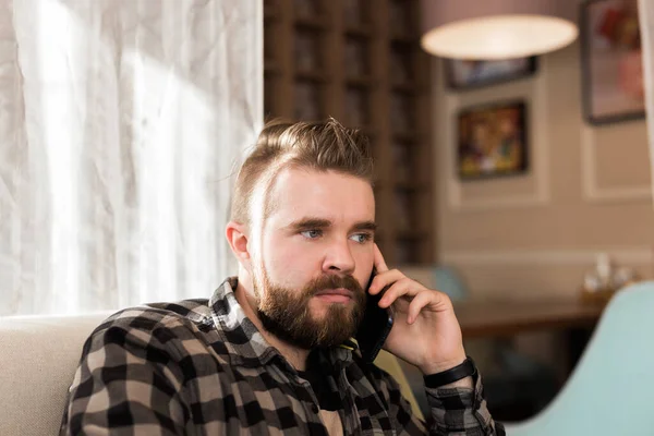 집약적 인 남자 가 카페에 앉아 휴대 전화로 이야기하고 있습니다. 의사소통 개념 — 스톡 사진