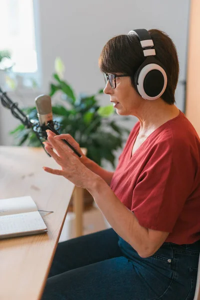 Middle-aged woman radio host making podcast recording for online show - broadcast and dj concept