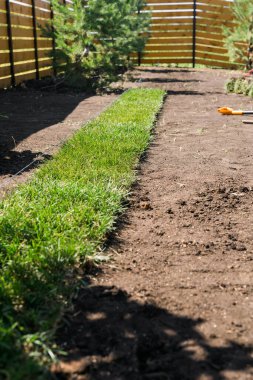 Installing new grass turfs from a roll - Garden building theme