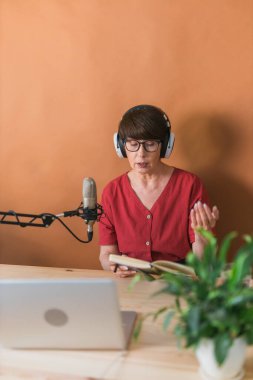 Middle-aged woman radio host making podcast recording for online show - broadcast and dj concept