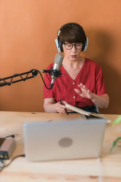 Middle-aged woman radio host making podcast recording for online show - broadcast and dj concept — Stockfoto