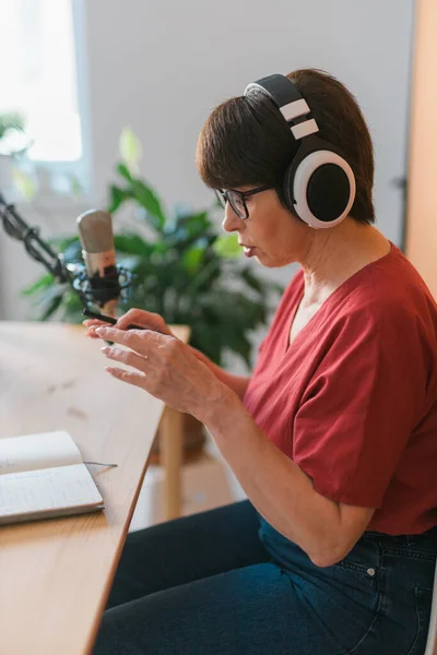 Middle-aged woman radio host making podcast recording for online show - broadcast and dj concept