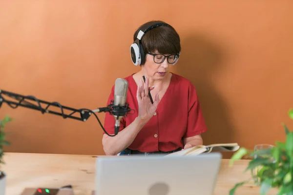 Middle-aged woman radio host making podcast recording for online show - broadcast and dj concept — Photo