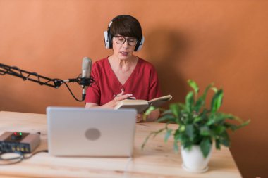 Middle-aged woman radio host making podcast recording for online show - broadcast and dj concept