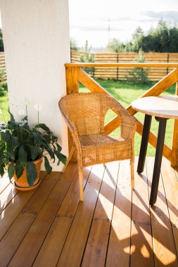 Cozy wooden terrace of country house or cottage with garden view - table and chair for relaxing evening
