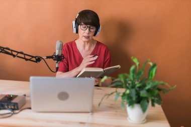 Middle-aged woman radio host making podcast recording for online show - broadcast and dj concept