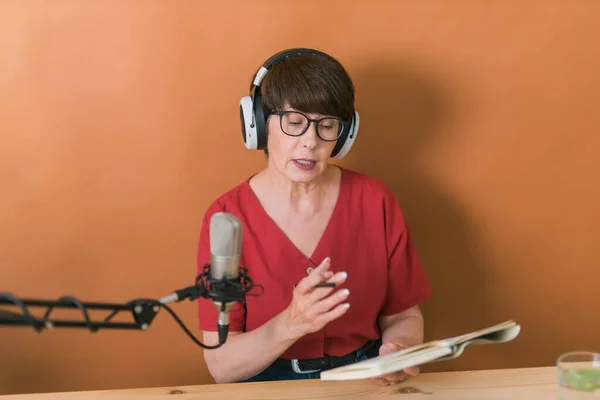 Middle-aged woman radio host making podcast recording for online show - broadcast and dj concept — Stockfoto