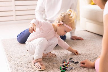 Cochlear implant for baby. Deaf child with hearing aid plays in living room.