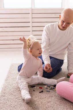 Cochlear implant for baby. Deaf child with hearing aid plays in living room.