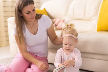 Child girl with cochlear implant with her mother at home. Hear impairment and deaf community concept