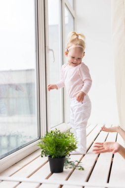 Cochlear implant for baby. Deaf child with hearing aid plays in living room. Health care and medicine technology and innovations