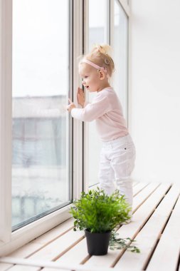 Cochlear implant for baby. Deaf child with hearing aid plays in living room. Health care and medicine technology and innovations