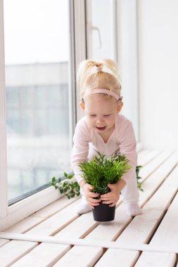 Cochlear implant for baby. Deaf child with hearing aid plays in living room. Health care and medicine technology and innovations