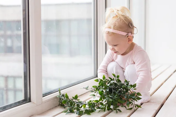 Cochlear implant for baby. Deaf child with hearing aid plays in living room. Health care and medicine technology and innovations - copy space and place for advertising — 스톡 사진