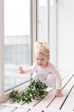 Cochlear implant for baby. Deaf child with hearing aid plays in living room